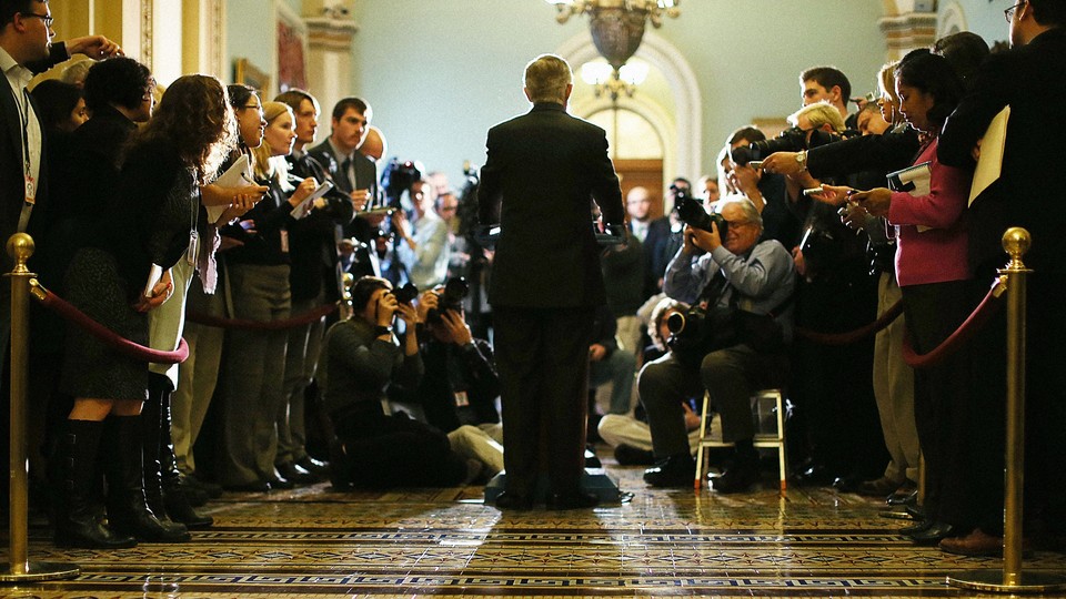 Harry Reid from behind, speaking to a crowd of journalists in 2005.