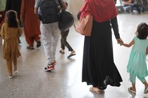 Parents walk with their young children through an airport