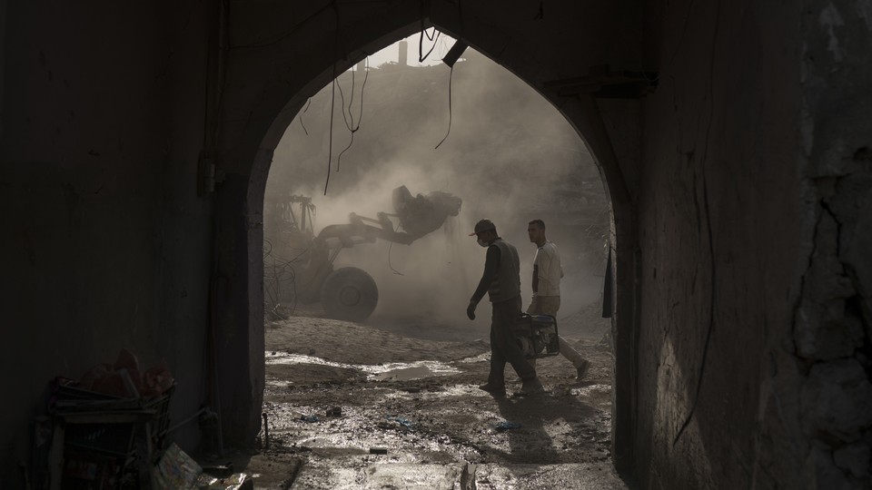 Construction workers remove debris from destroyed shops in Mosul in November 2017.