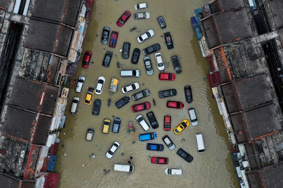 An aerial view of vehicles and buildings inundated by floodwater