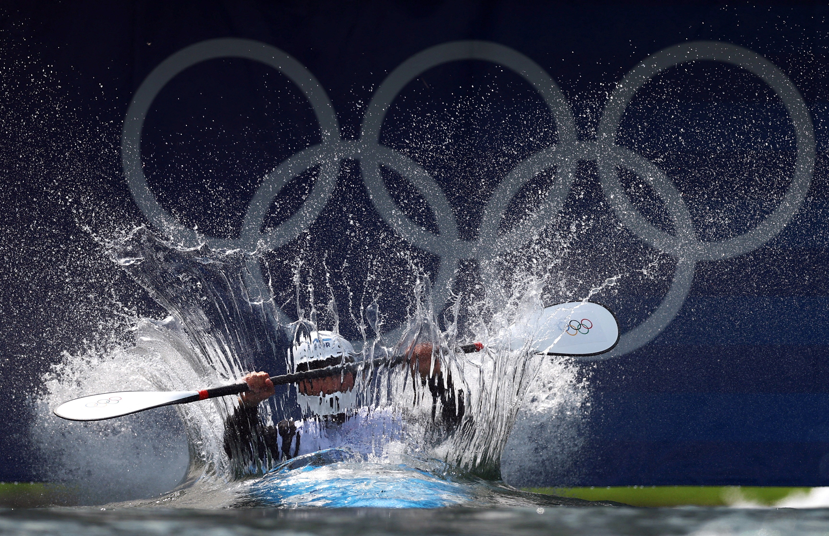 An athlete in a kayak makes a big splash as they drop into a course for a time trial run.