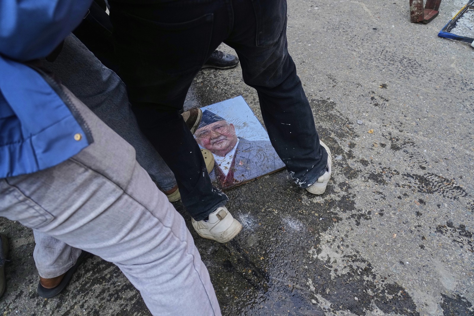 Demonstrators stomp on the photograph of the Prime Minister of Nepal.