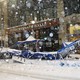 An outdoor dining tent is seen crumpled on the sidewalk during a snowstorm