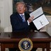 President Trump holding a signed memorandum
