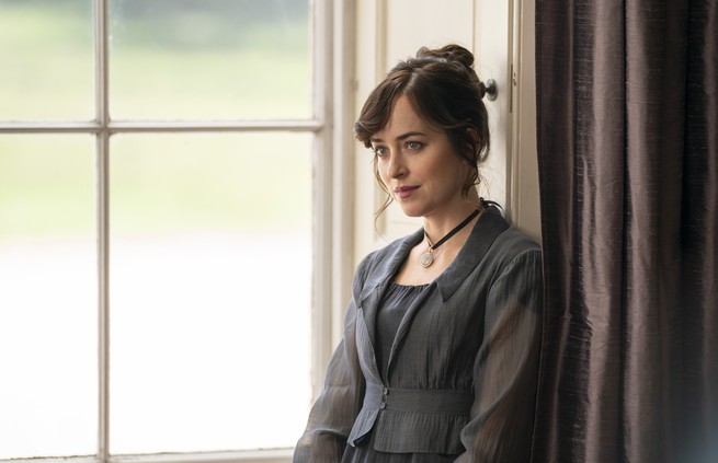 A scene from the film "Persuasion," depicting Dakota Johnson as Anne Elliott, sitting by a large window