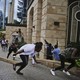 Civilians run with their heads down from the Nairobi hotel complex where terrorists killed at least 14 people on Tuesday.