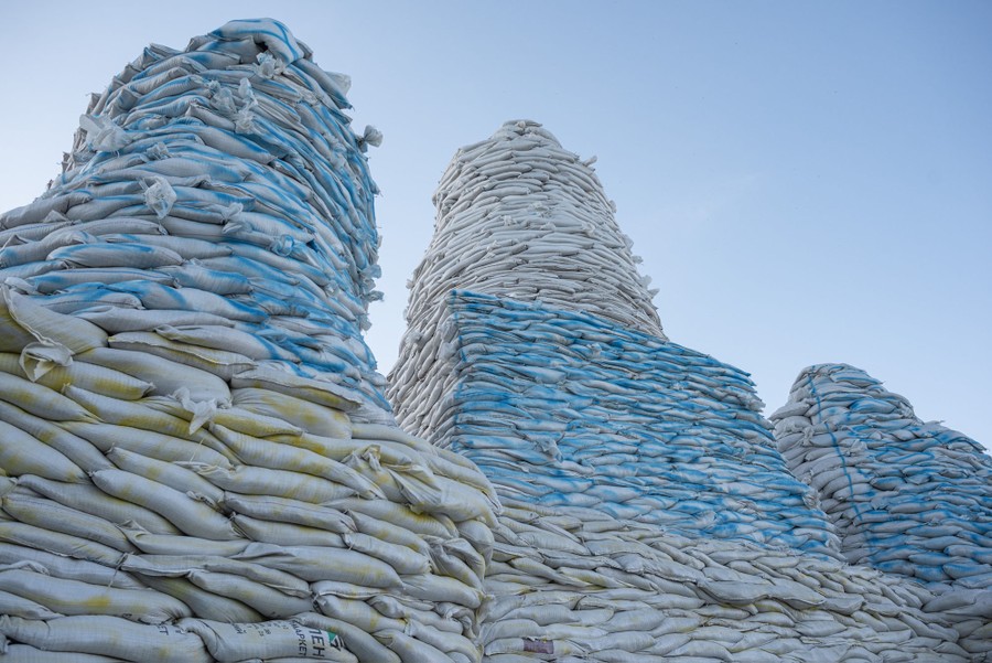 Large piles of sandbags are stacked around a monument.