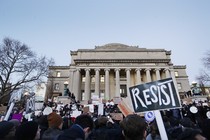 A group of students holds signs that read "resist" outside the Columbia University Library.