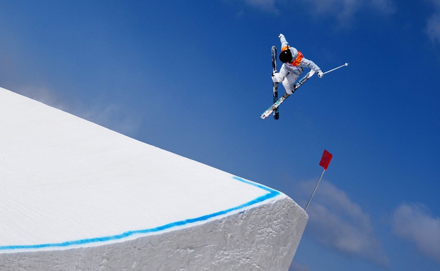A freestyle skier makes a jump off a ramp during a run.