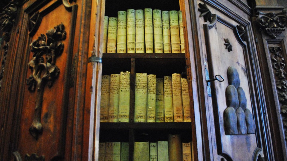 Green and red lighting reveals several books on wooden shelves