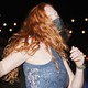A woman dances at a party while wearing a mask