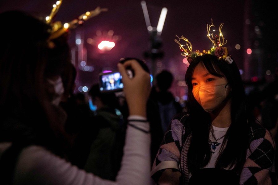 Revelers take photos during a fireworks-and-laser show.