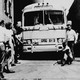 black and white photo of man sitting in front of bus to Birmingham