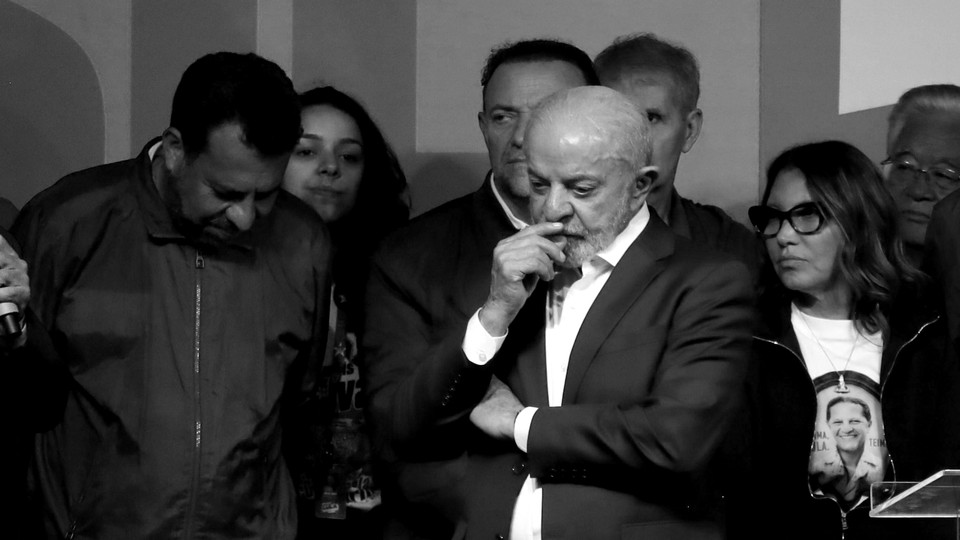 Black-and-white photo of Luiz Inácio Lula da Silva, surrounded by other people