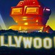 Illustration of a robot standing behind the illuminated Hollywood sign at night