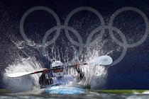 An athlete in a kayak makes a big splash as he drops into a course for a time-trial run.