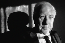 A black-and-white close-up photo of David McCullough from the shoulders up; he is wearing a suit and tie and smiling gently.