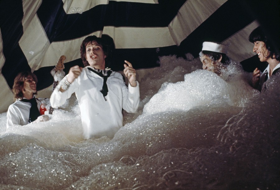 Members of the Rolling Stones perform in a room filled with soap bubbles for a music video.
