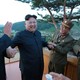 North Korean leader Kim Jong Un reacts with scientists and engineers.