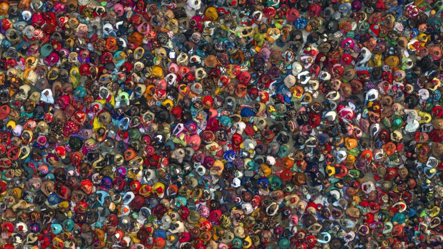 An aerial view of a large crowd of people wearing colorful clothing