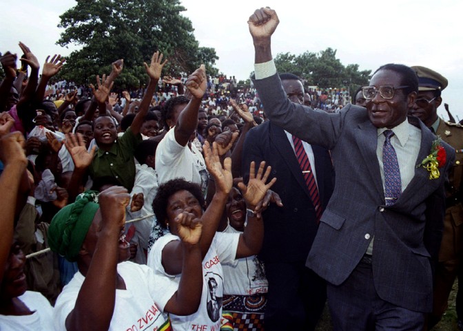 Robert Mugabe raises his fist at a packed election rally.