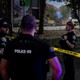 A color photograph of police standing in a street, attending the scene of a terror attack in Boulder, Colorado.