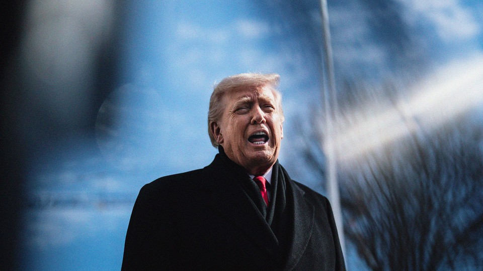A photo of Trump talking, wearing his winter coat in front of a blurred-out background of a flag pole and bare winter trees