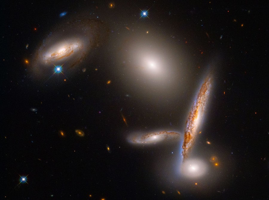 Five galaxies appear in space, crowded very closely together.