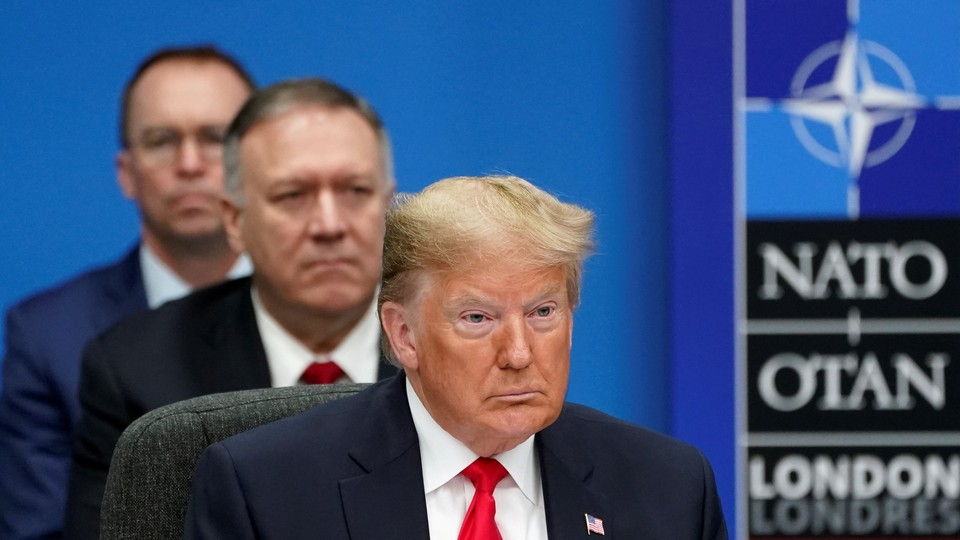 Donald Trump, Mike Pompeo, and Mick Mulvaney sit in a line while attending a NATO summit.