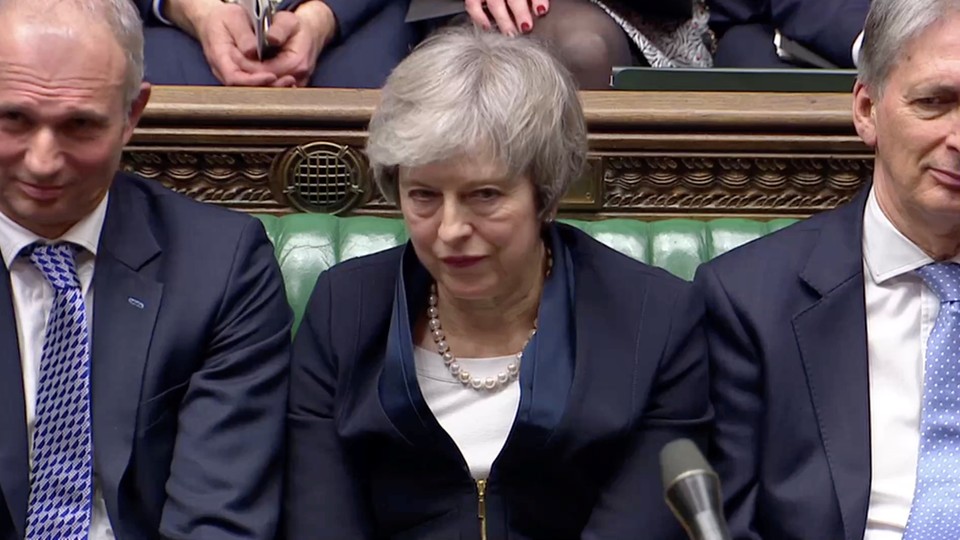 Theresa May sits in Parliament after the body overwhelmingly voted down her Brexit plan.