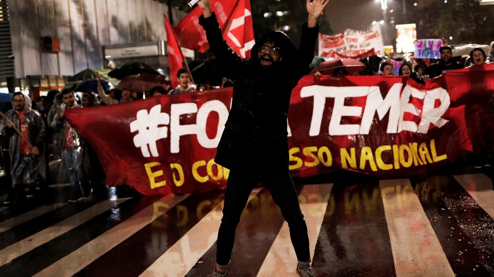 Demonstrators take part in a protest against Brazil's President Michel Temer in Sao Paulo, Brazil, on May 18, 2017. The banner reads "Out Temer." 