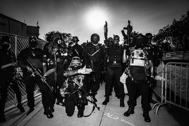 people posing with guns wearing black