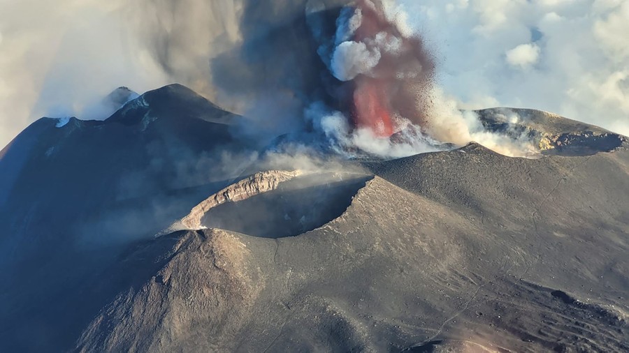 An aerial view of an eruption of Mt. Etna, with lava, gas, and steam flying into the air