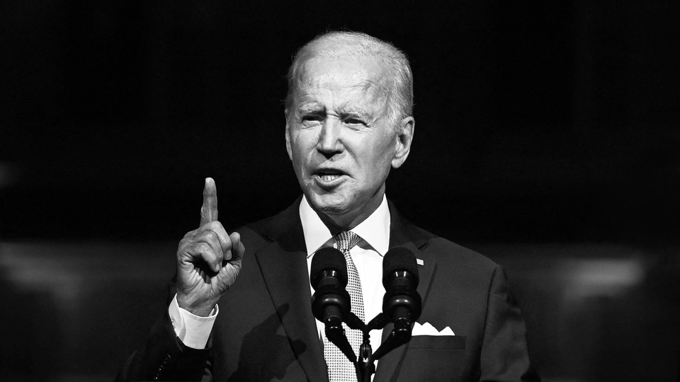 A black-and-white photo of Joe Biden delivering an address