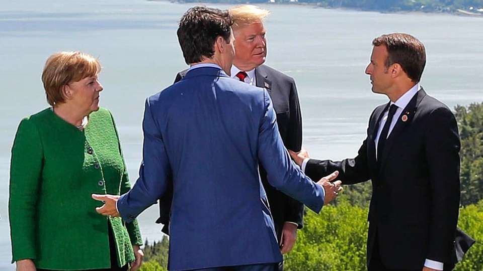 German Chancellor Angela Merkel, President Donald Trump, Canadian Prime Minister Justin Trudeau, and French President Emmanuel Macron chat at the G7 Summit in Charlevoix, Quebec on June 8, 2018. 