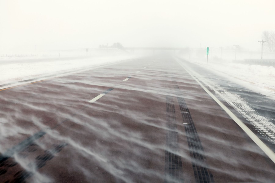 Snow blows across a highway.