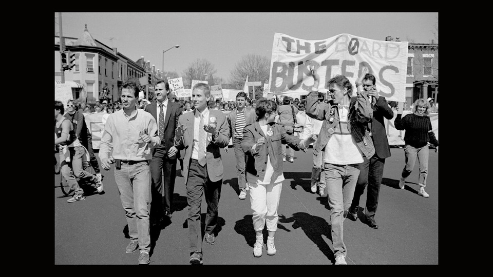 A black-and white still from the documentary "Deaf President Now!" showing Gallaudet University student protesters assembled outside.
