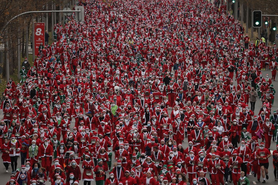Thousands of people dressed as Santa Claus take part in a race.