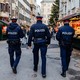 Three police officers patrol through a Christmas market to monitor compliance with the lockdown.