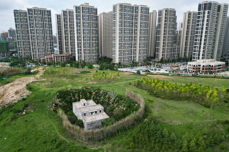 A small, isolated house whose owners refuse to leave sits in a pit near new high-rises.