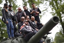 Members of the Night Wolves motorcycle group pose on top of a Red Army tank.