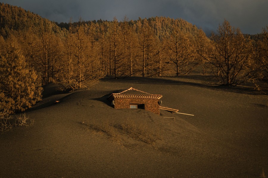 A house sits buried in volcanic ash.