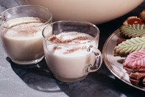 Eggnog on a table with lit candles.
