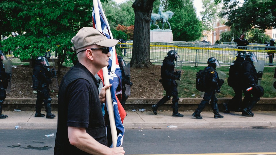 A white nationalist is seen leaving Emancipation Park in Charlottesville, Virginia, where violent clashes took place between counter-protesters and white-nationalist groups. Hundreds of white nationalist gathered at the park for a “Unite The Right” rally to protest the removal of the statue of Robert E. Lee, which is seen in the background.