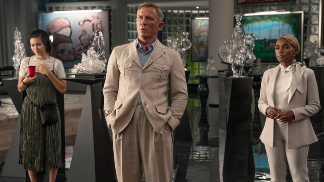 Jessica Henwick, Daniel Craig, and Janelle Monáe stand in a gallery space in "Glass Onion"