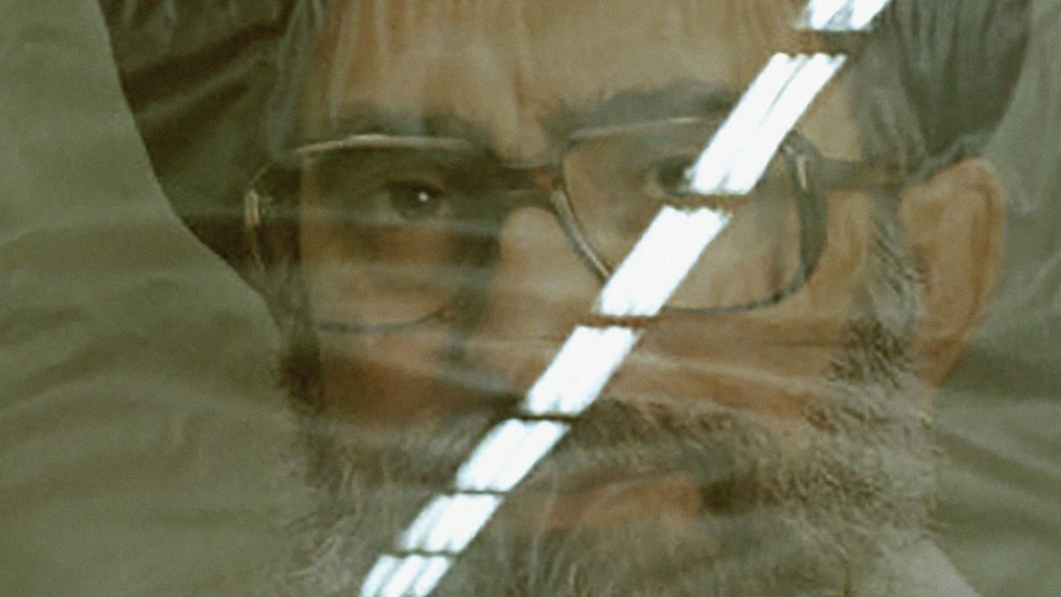 A distorted portrait of Khamenei with the reflection of overhead lights over one of his eyes