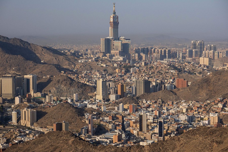 A view of many large and small buildings nestled in valleys alongside treeless hills.