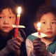 Children hold candles during the Easter mass at a church in Xiaohan village of Tianjin municipality in 2009.