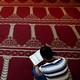 A Muslim faithful reads the Quran inside a makeshift mosque.