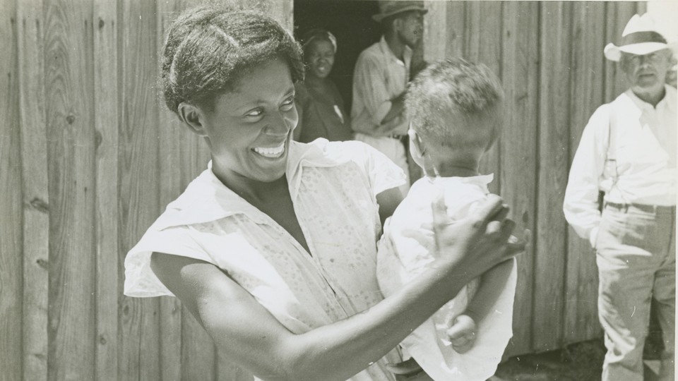 A woman holds a child.